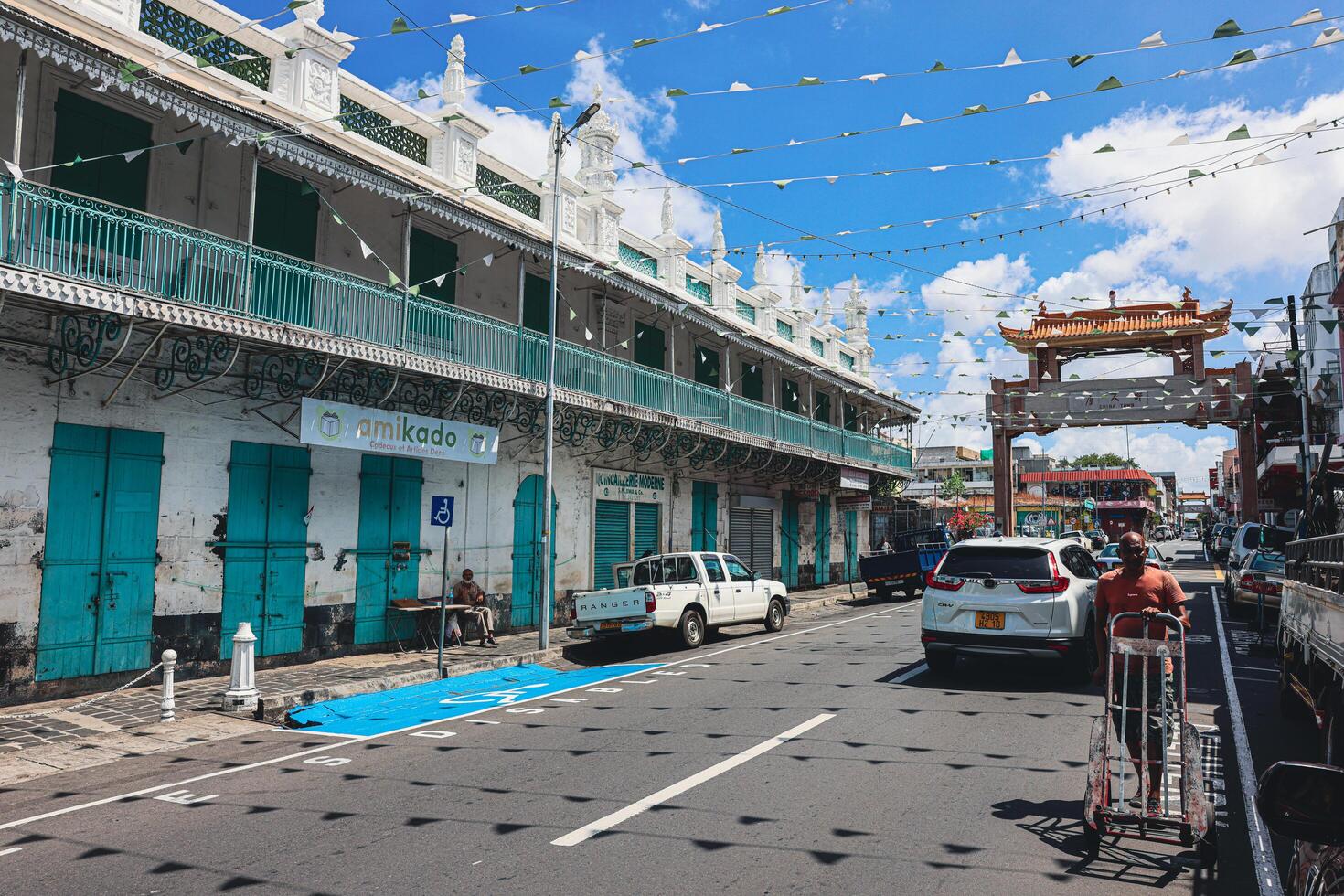 Port Louis, Mauritius - January 14, 2023 - A diverse group of individuals standing in front of a building, located in Port Louis City, Mauritius, with a prominent mosque in the background. photo