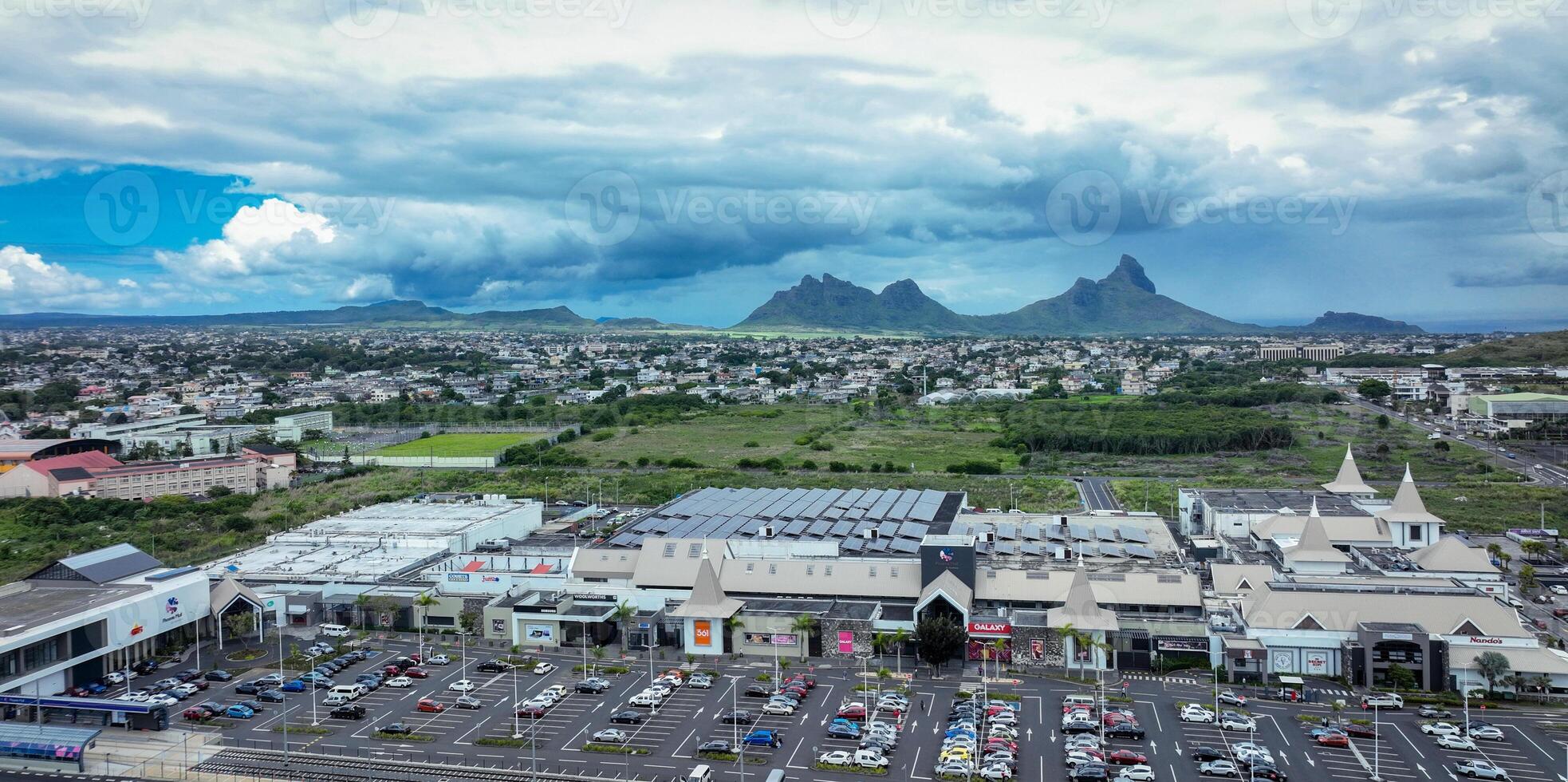 An aerial photograph capturing the city of Quatre Bornes with majestic mountains forming a stunning backdrop. photo