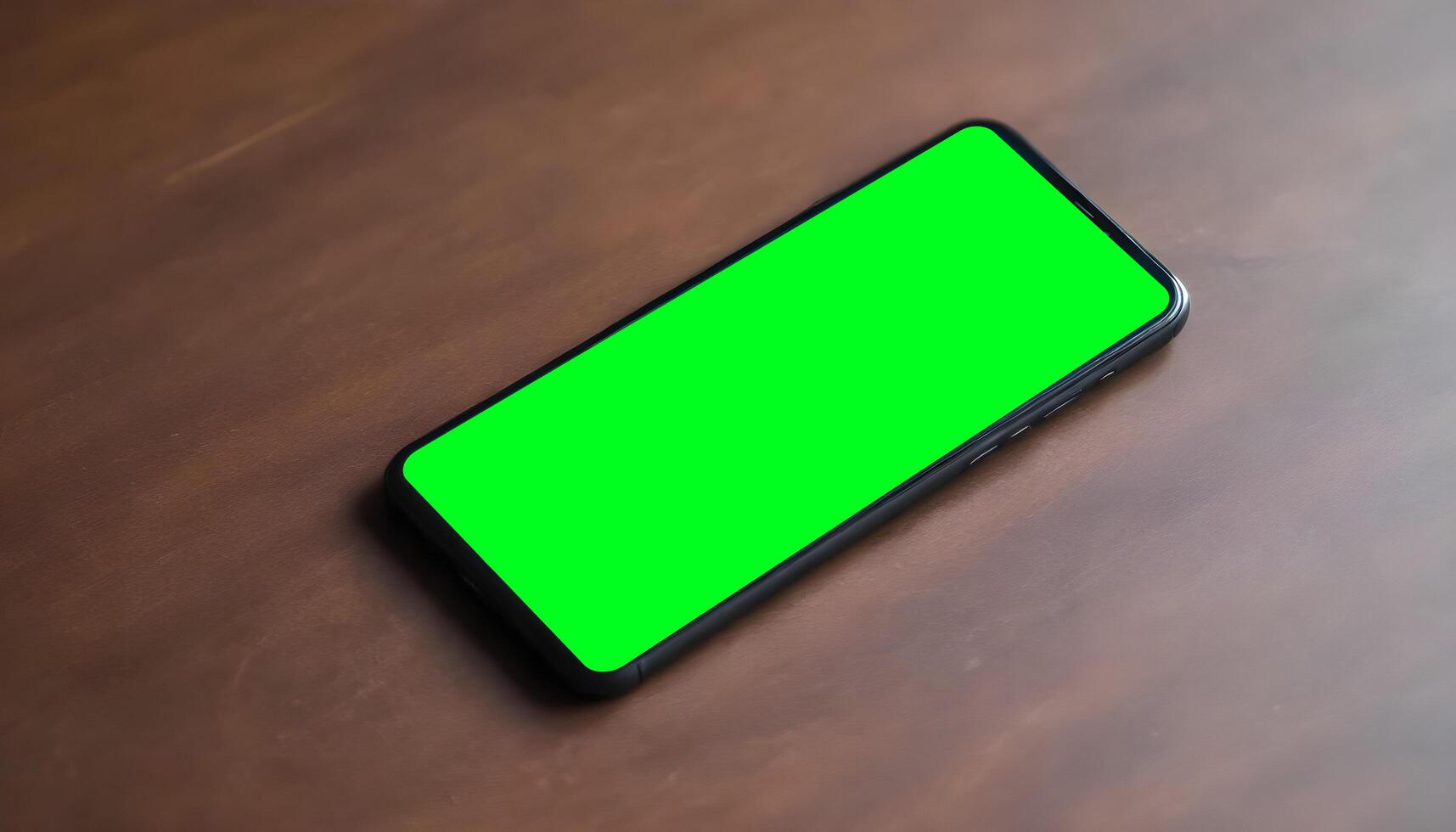 Hand holding black mobile phone with blank green screen photo