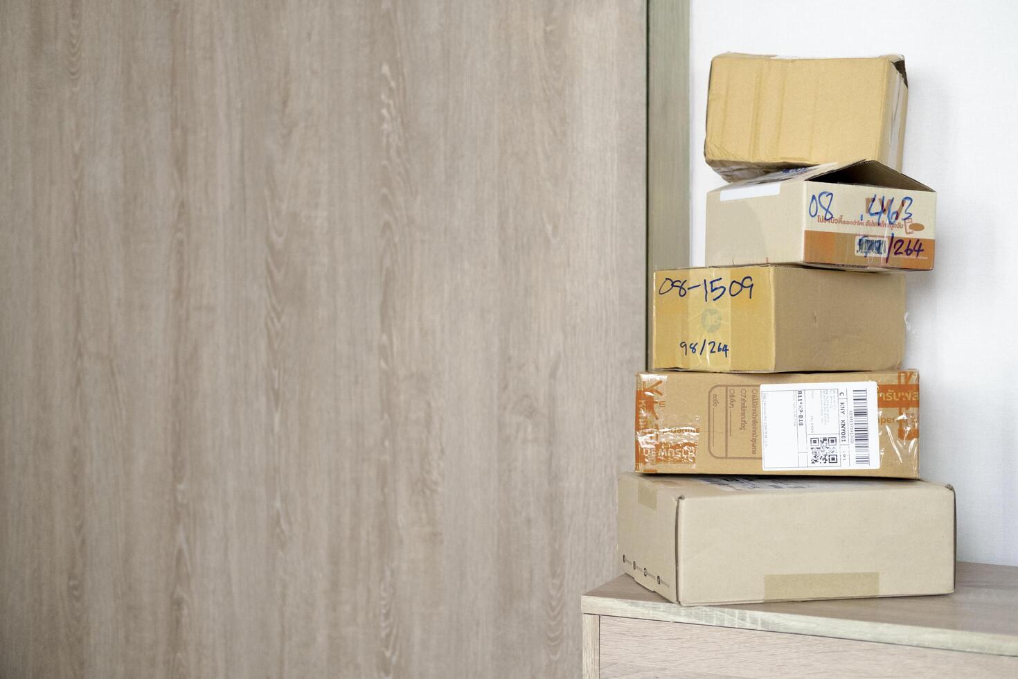 Cardboard boxes on wooden bench near entrance wood door. Parcel delivery service or shopping online photo