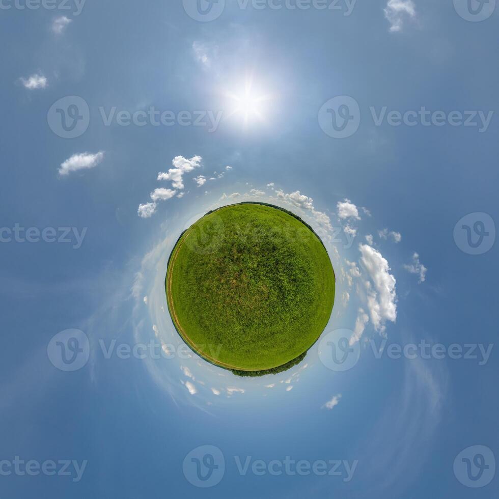 simple little tiny planet without buildings in blue sky with beautiful clouds. Transformation of spherical panorama 360 degrees. Spherical abstract aerial view. Curvature of space. photo