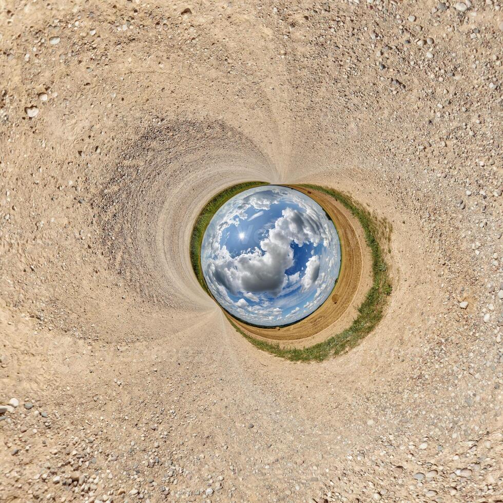 blue hole sphere or globe little planet inside sand or dry ground frame background with tractor tracks photo
