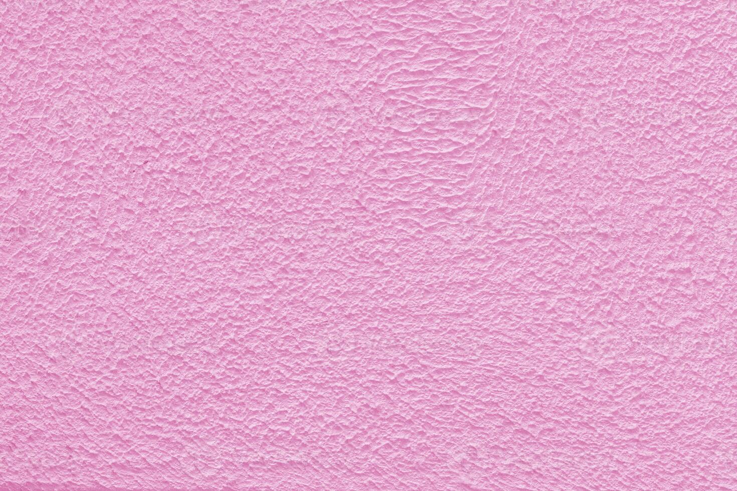 Pink plaster wall of a building. Rough surface texture. photo