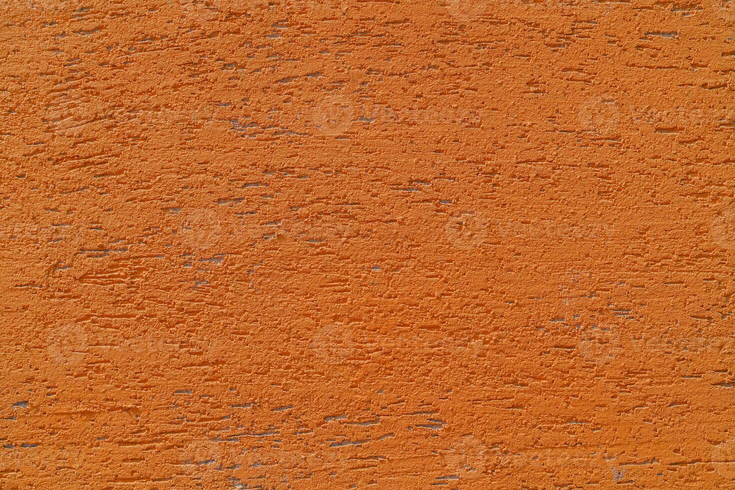 Orange plaster wall of a building. Rough surface texture. photo