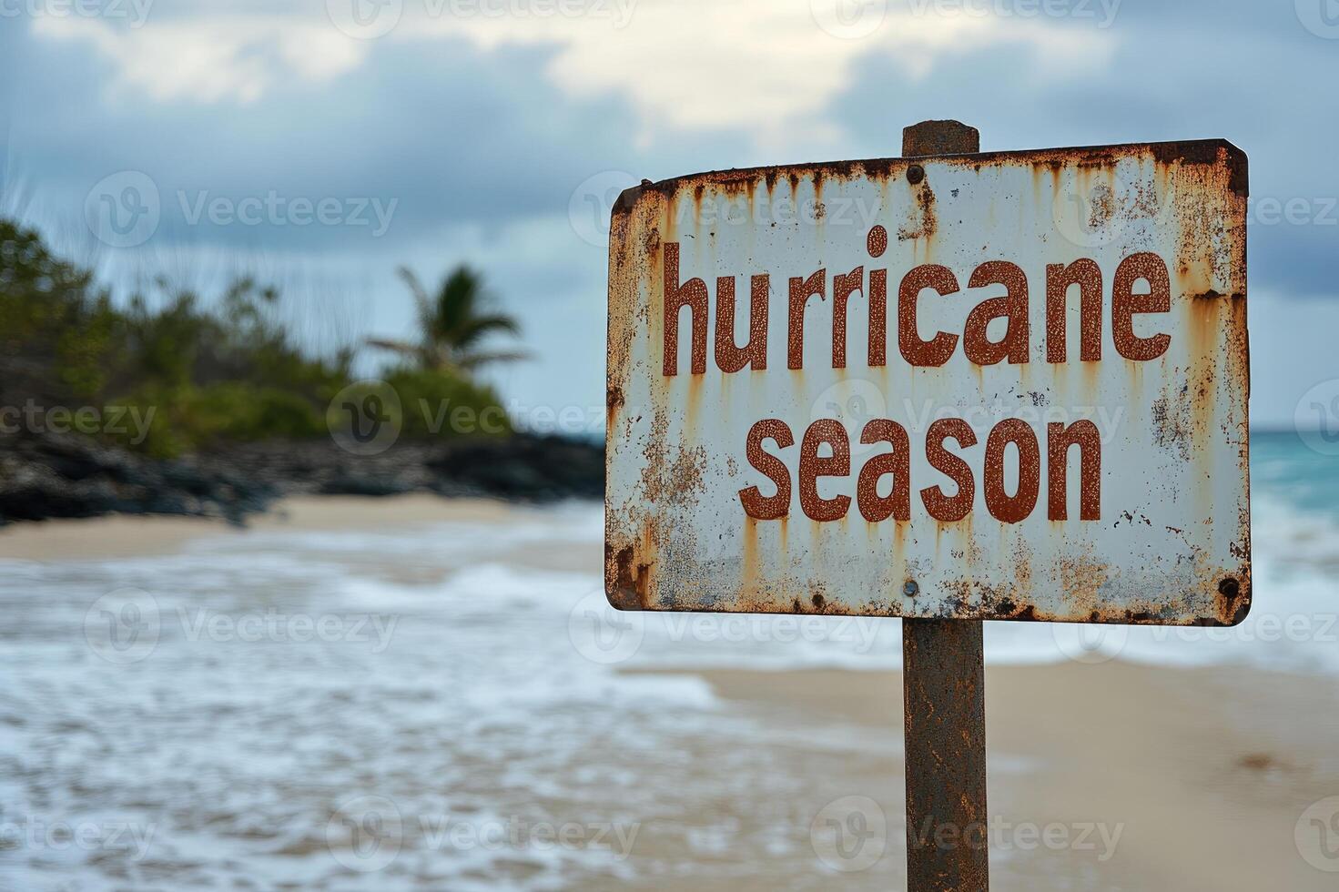 Rusty hurricane season sign announcing potential danger on tropical beach photo