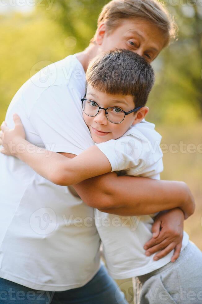 Grandmother and her little grandchild together in sunny summer park photo