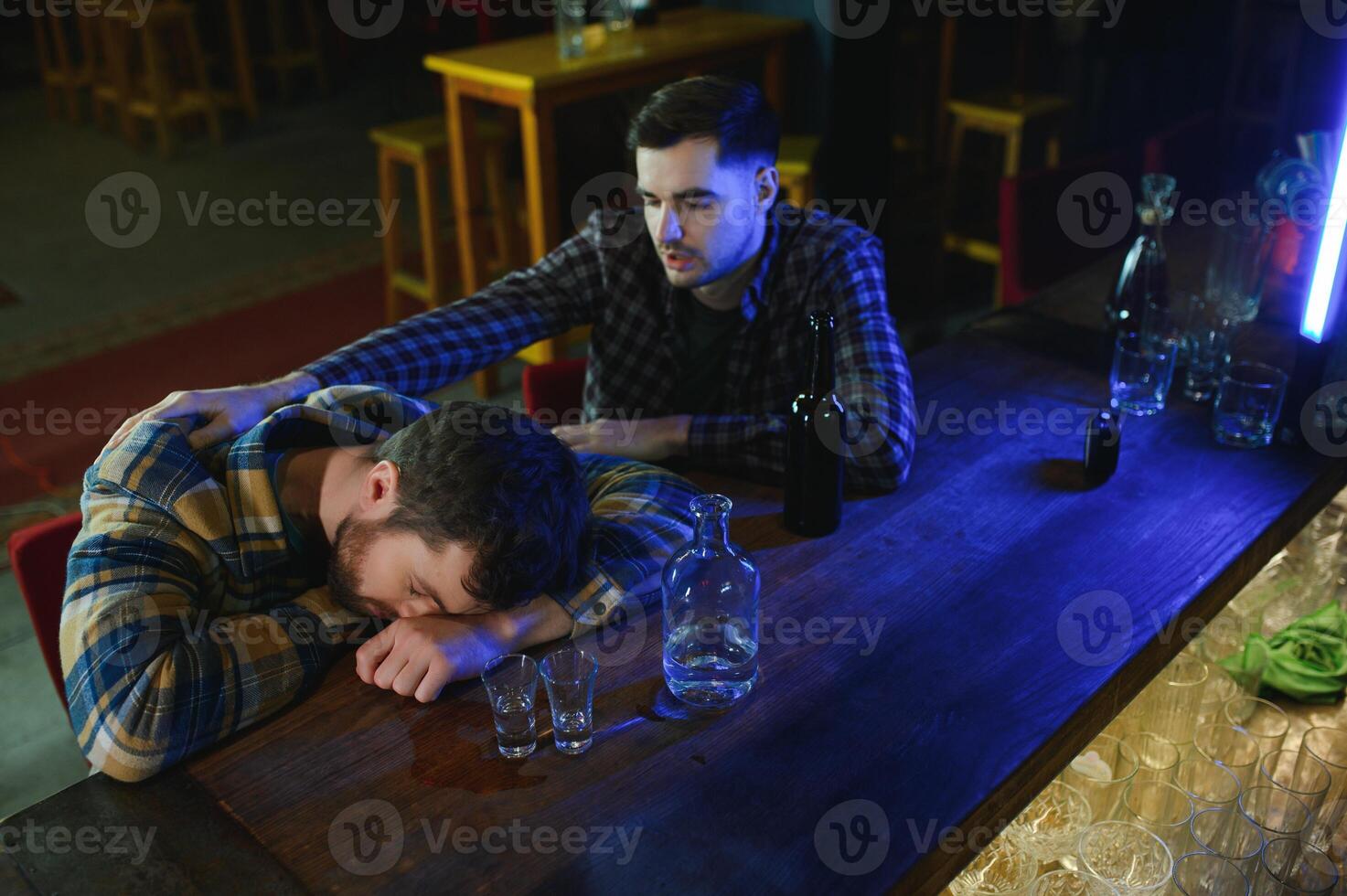 Drunk man sleeps at bar counter, alcohol addiction photo