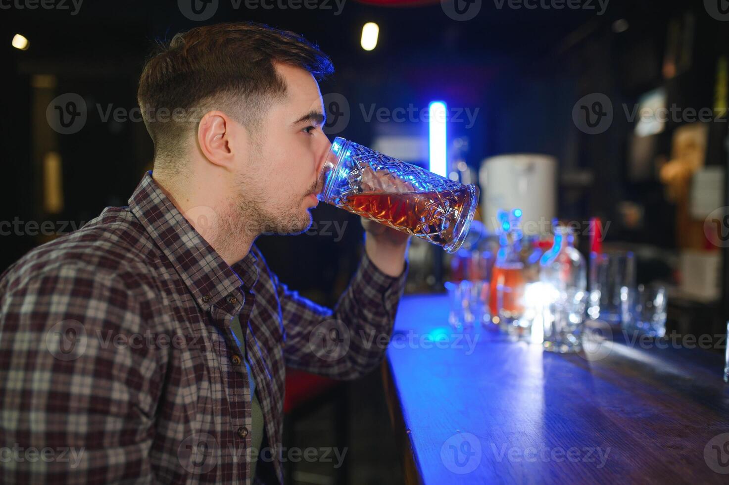 Night in bar. Portrait of cheerful men drinking beer at the bar photo