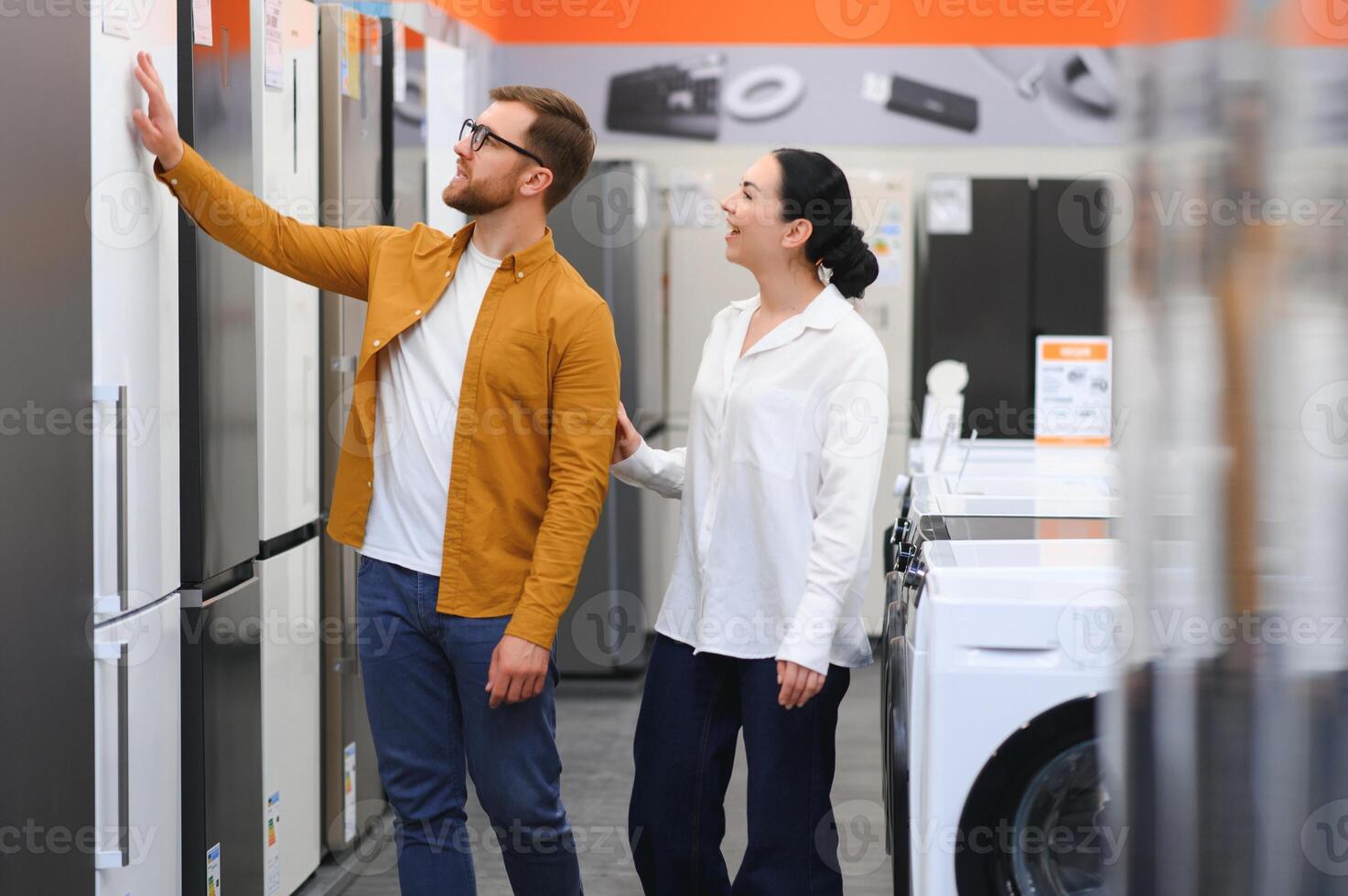 family couple buying domestic refrigerator in supermarket photo