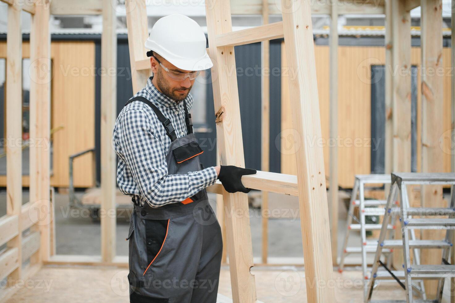 Worker carpenter assembling a modular house photo