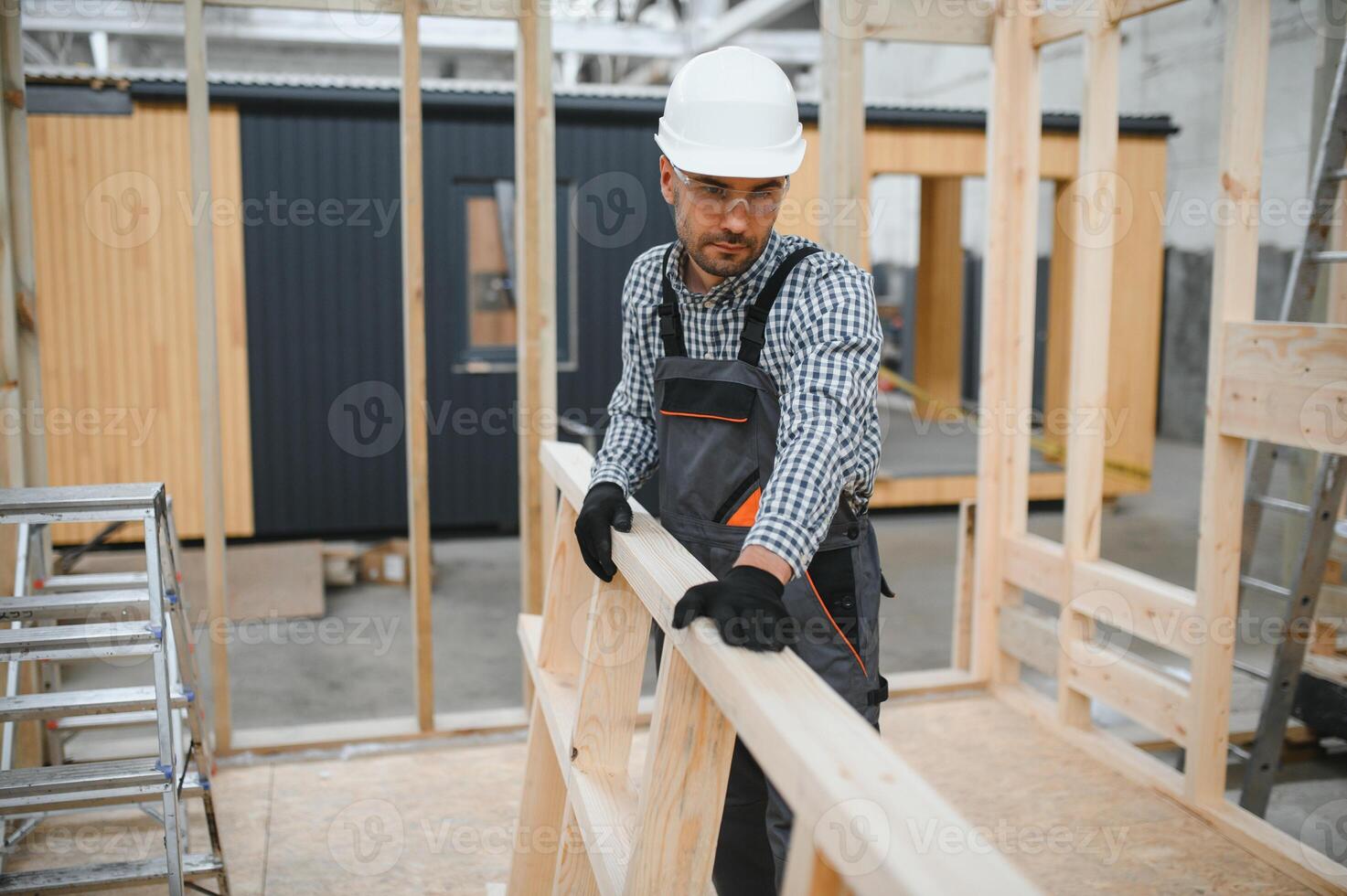 Process of construction new and modern modular house. Worker man in special protective uniform wear working on building development industry of energy efficient property photo