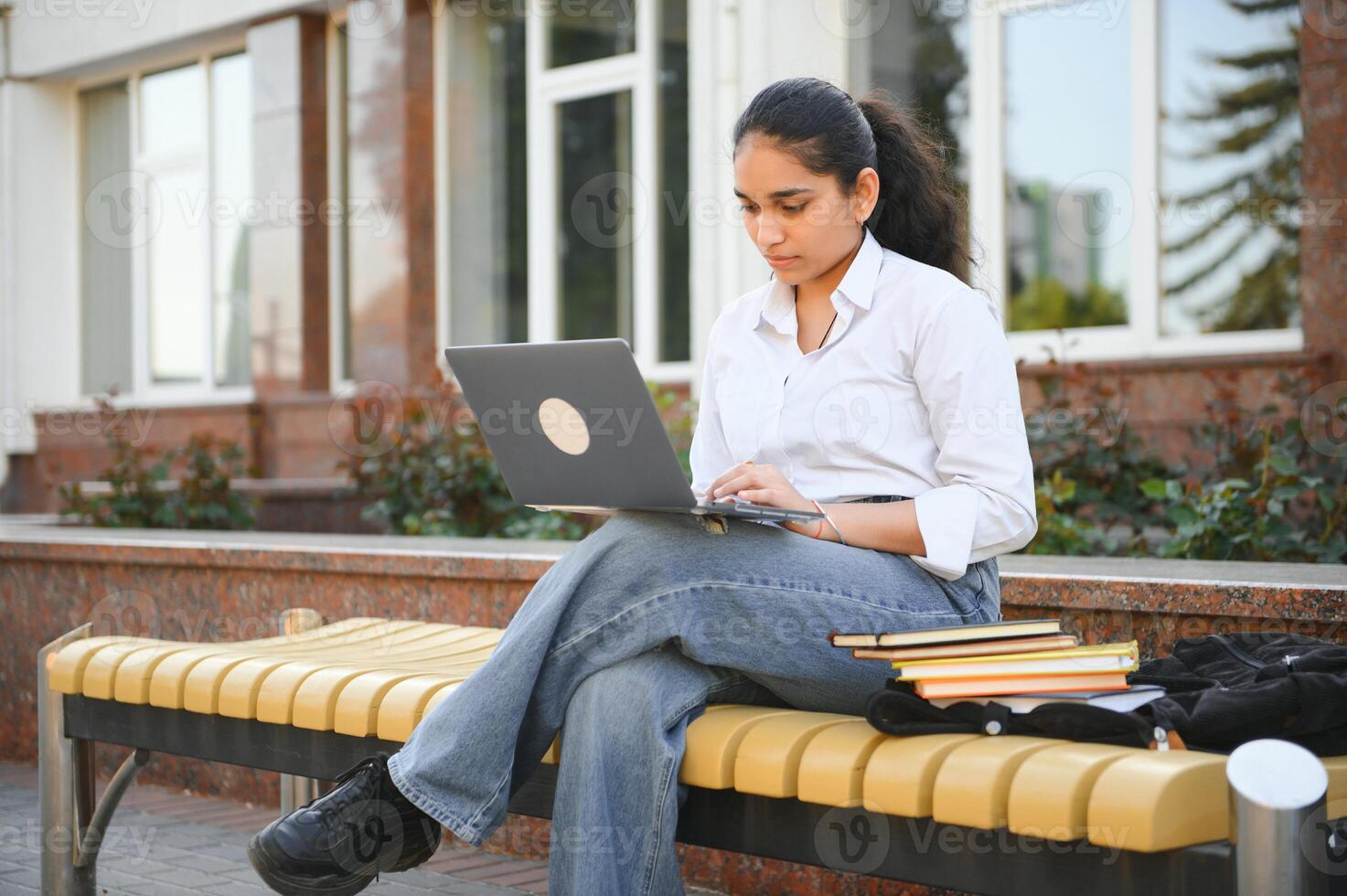 Portrait of Indian girl student with books near university photo