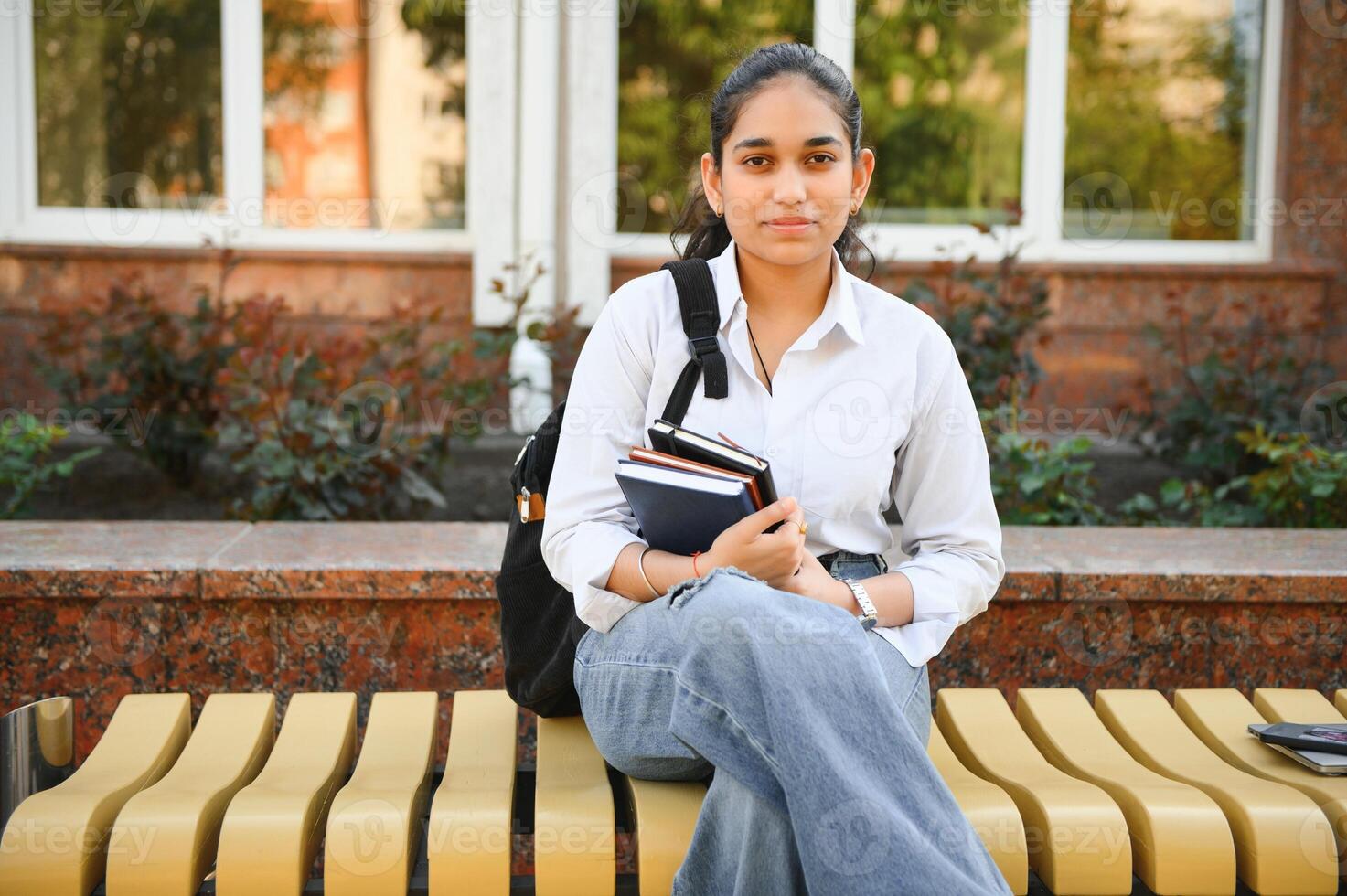 Portrait of Indian girl student with books near university photo