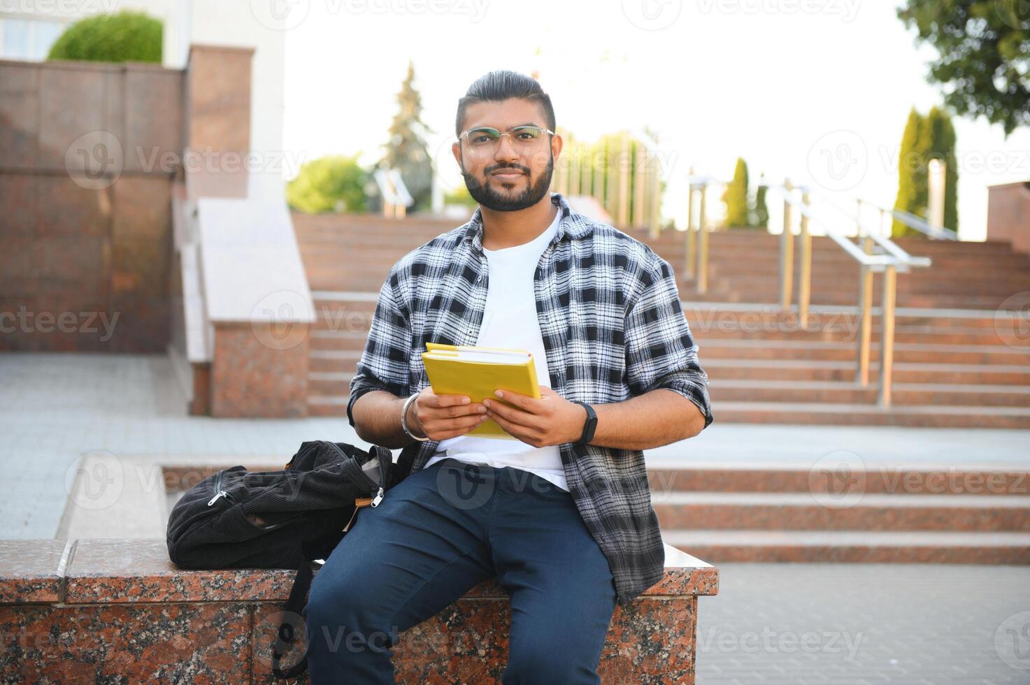 Handsome young Indian boy student with books and backpack. Education concept photo
