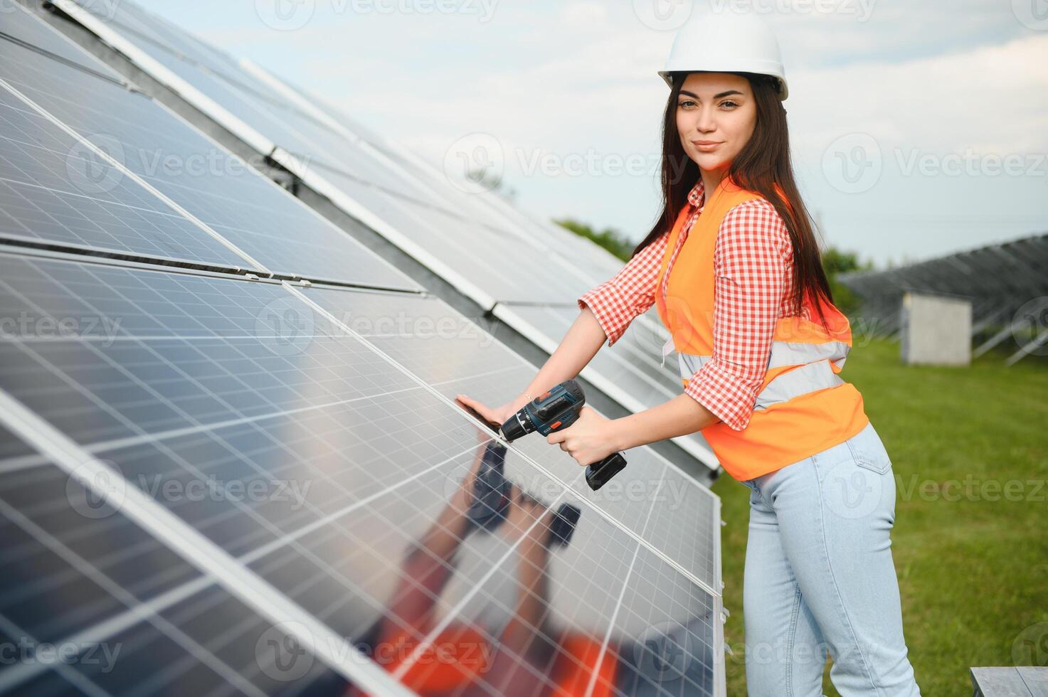 Beautiful young engineer near solar panels outdoors. Installation of solar panels. photo