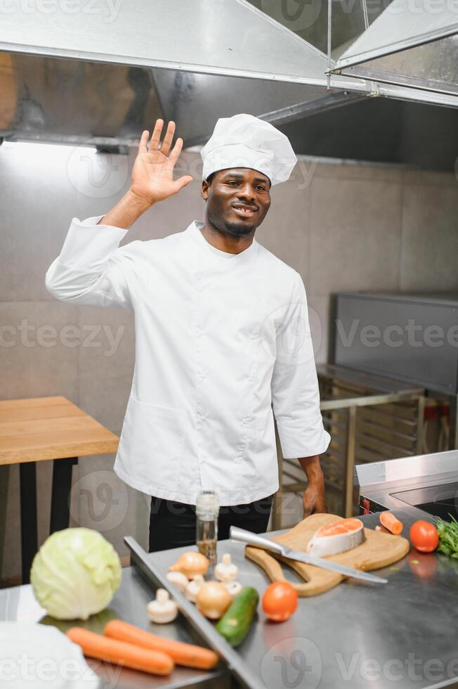 African American male chef preparing salmon fish in restaurant kitchen photo