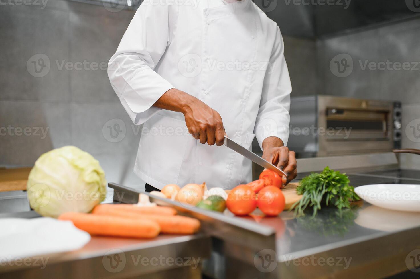 African American chef cooking tasty salad in kitchen photo