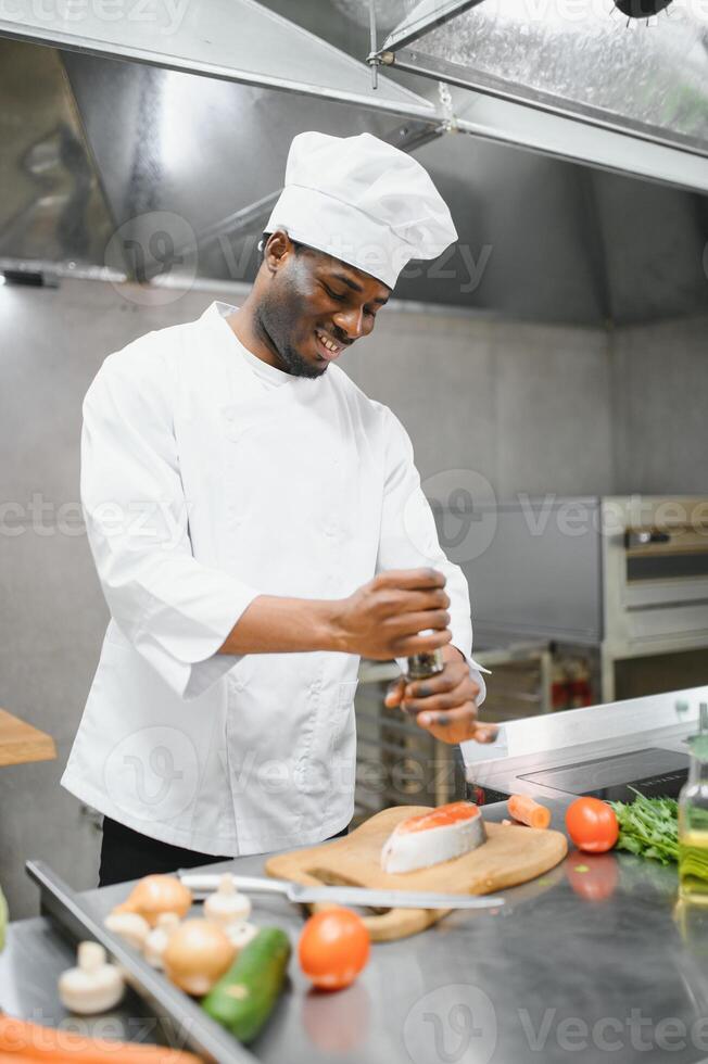 Gourmet chef in uniform cooking in a commercial kitchen. photo