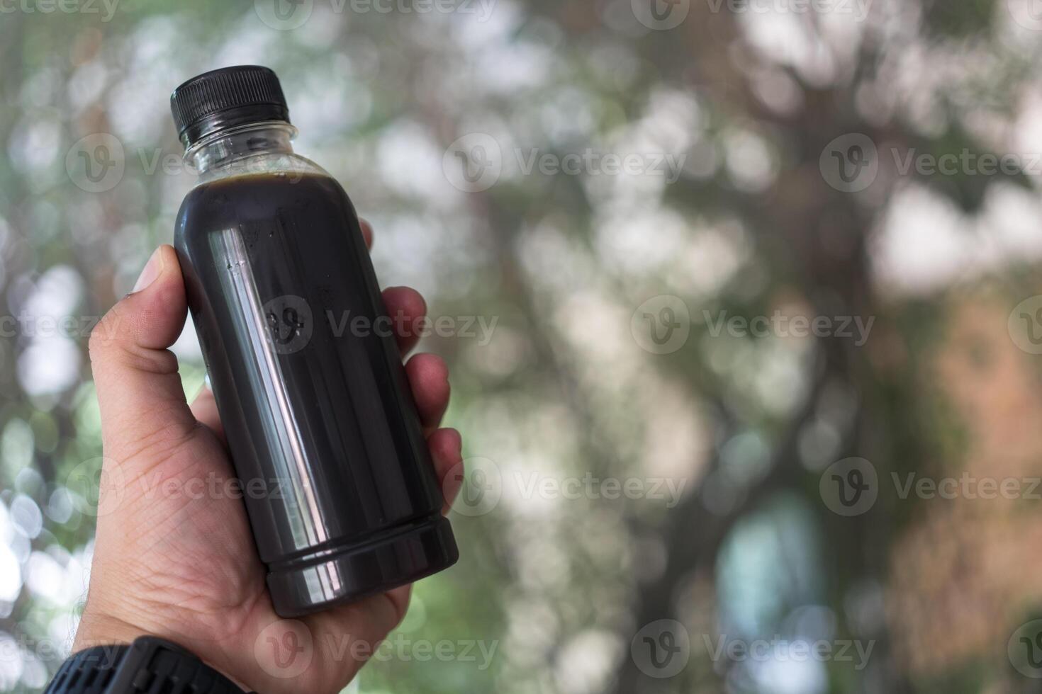 Hand holding cold brew coffee bottle. photo