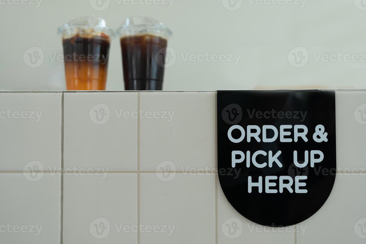 Order and pick up here in the counter in a coffee shop and two iced coffee. photo