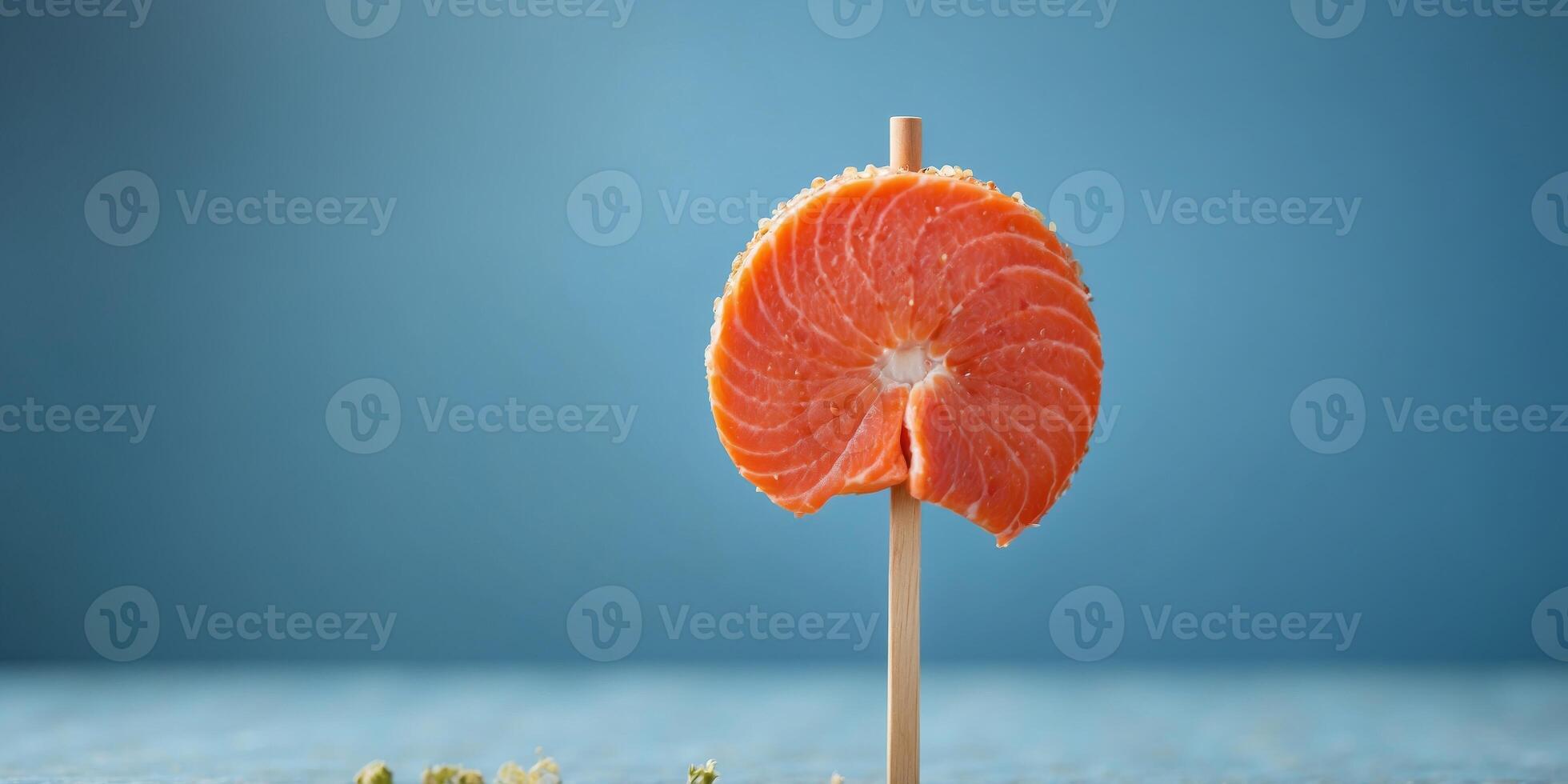 Slice of salmon on a stick Blue background Minimal food concept Copy space. photo