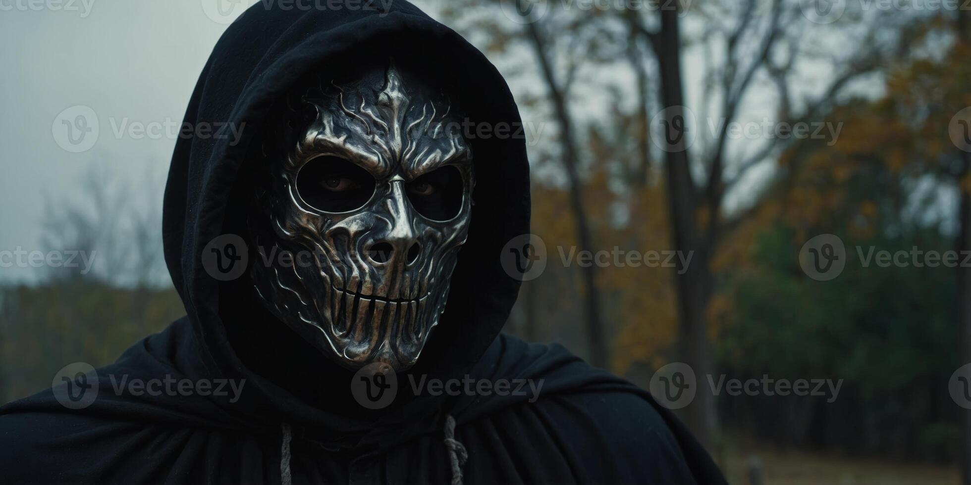 masked man wearing a black cloak evil spooky monster looking man. photo