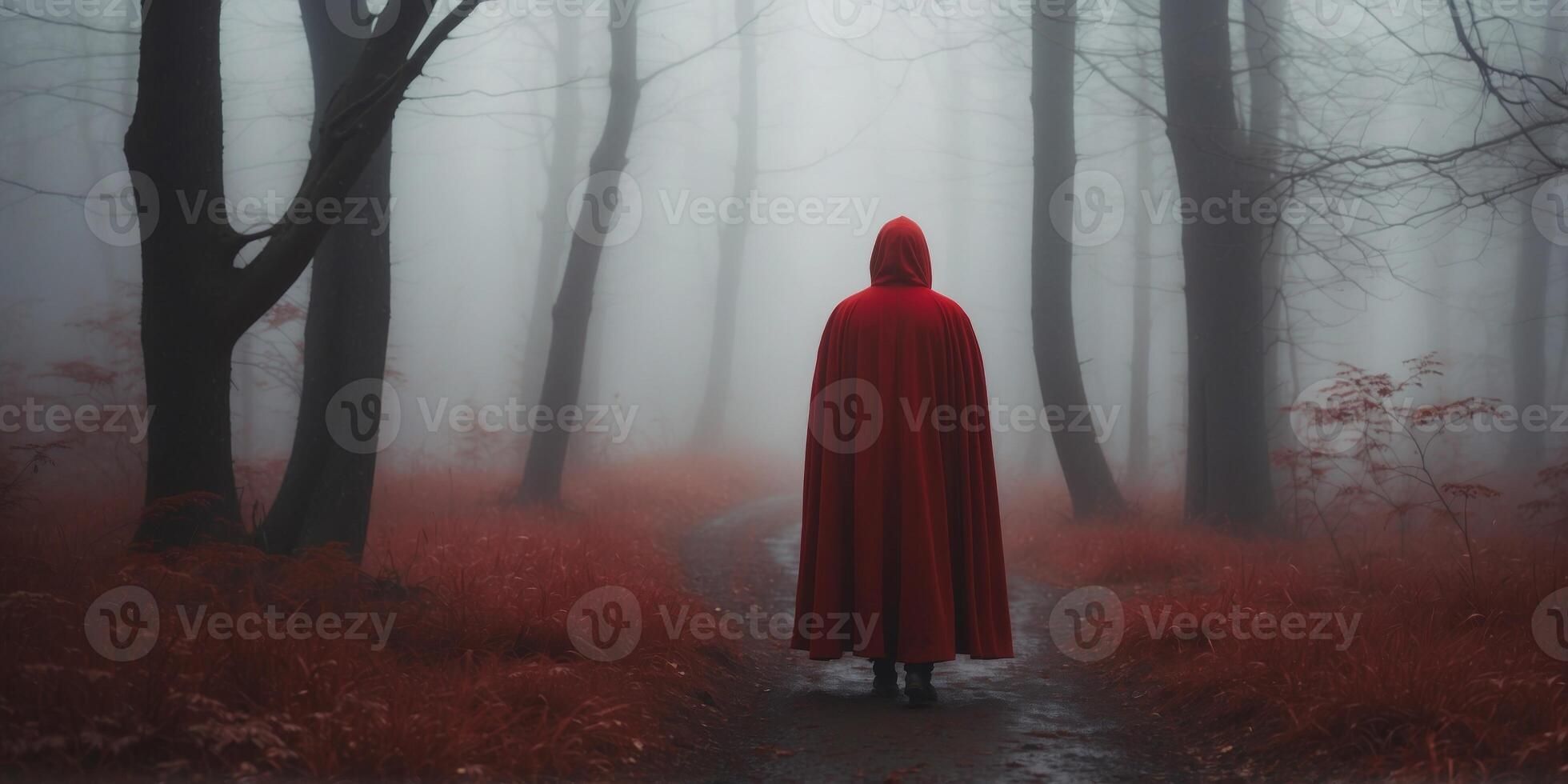 Mysterious figure in red cloak wandering in foggy forest. photo