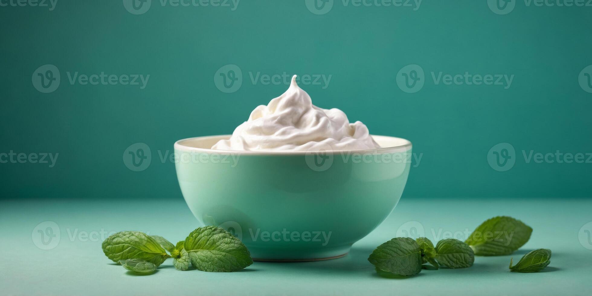 Top view of bowl with white quark or cream on mint green background. photo