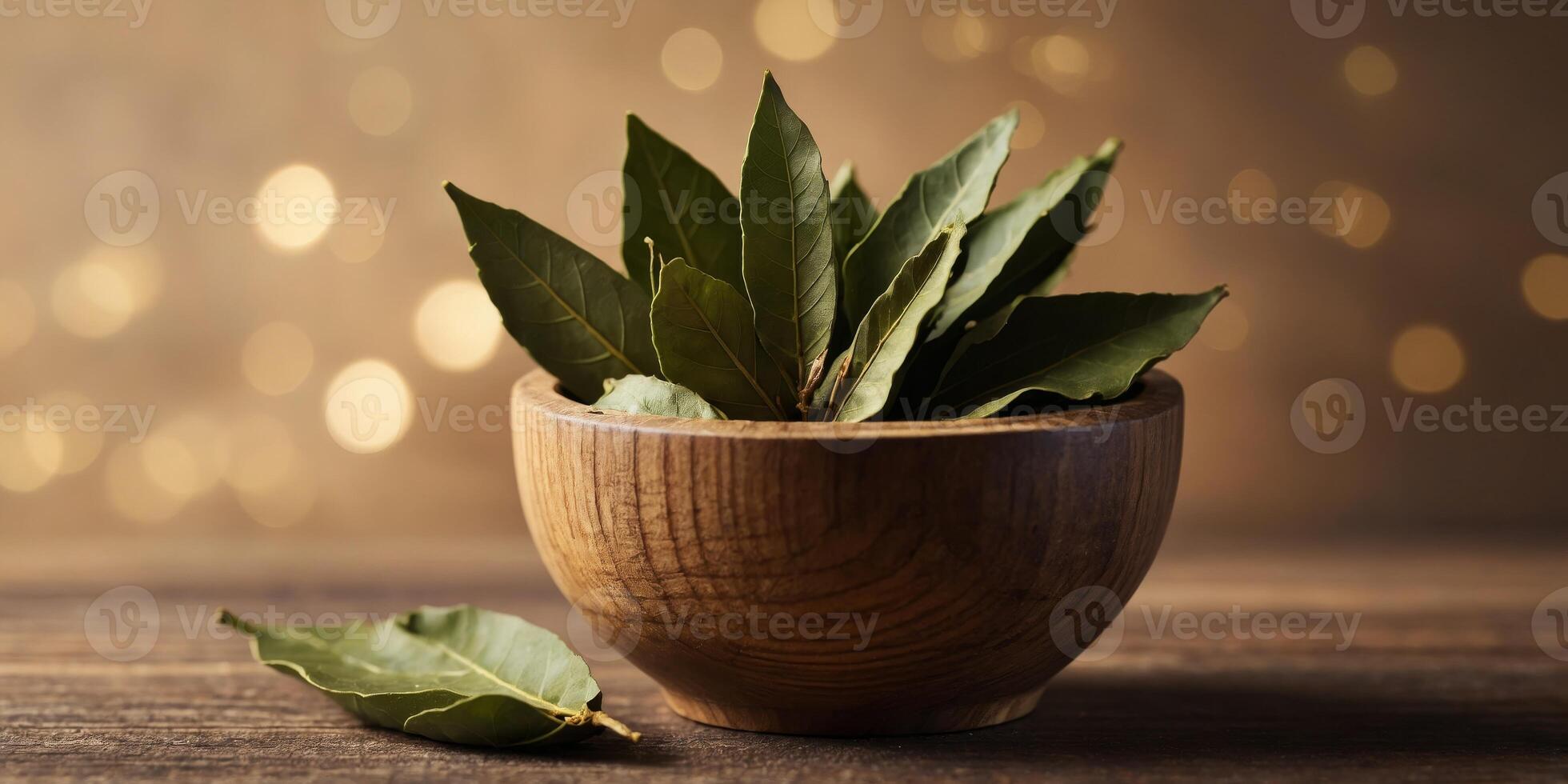 Crushed bay leaf in a wooden cup A whole bay leaf. photo