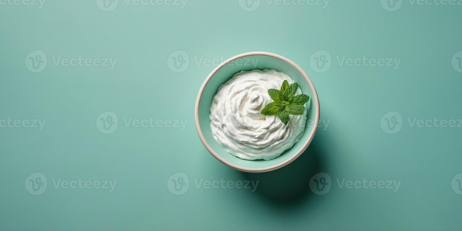 Top view of bowl with white quark or cream on mint green background. photo