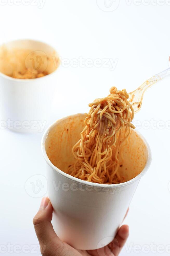 Woman's Hand Holding Plastic Fork Eating Instant Noodles photo