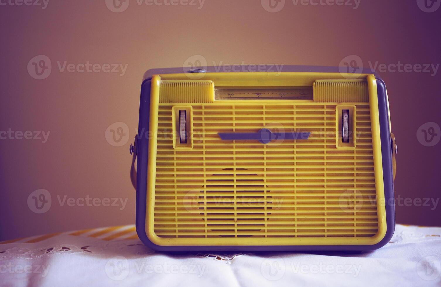 a yellow and blue radio sitting on a bed photo