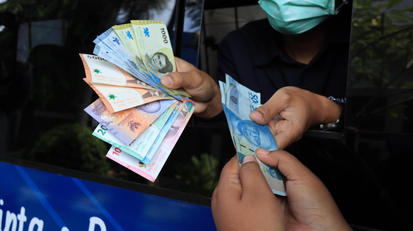 Residents queue to exchange new rupiah banknotes at Bank Indonesia services photo