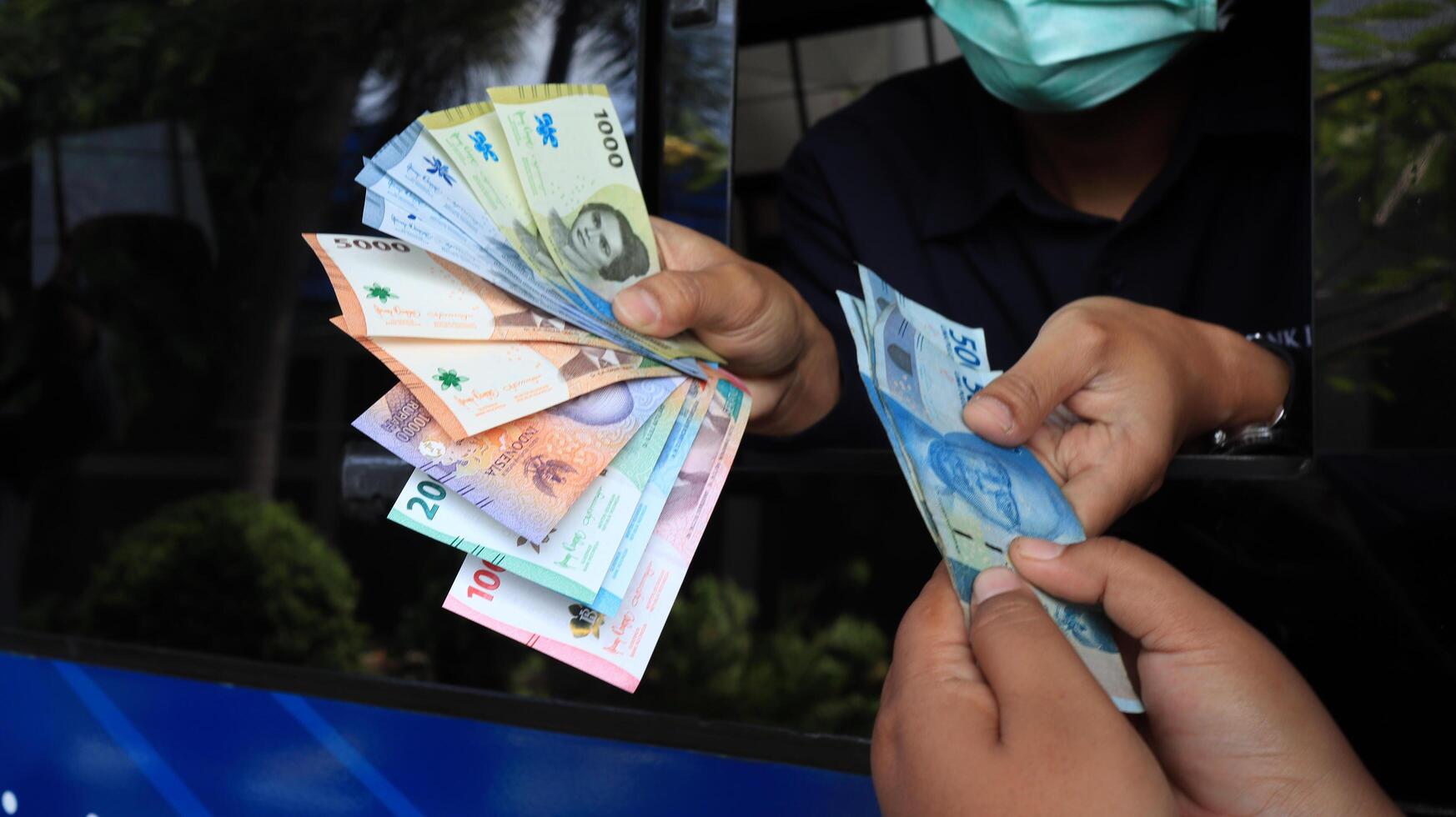 Residents queue to exchange new rupiah banknotes at Bank Indonesia services photo