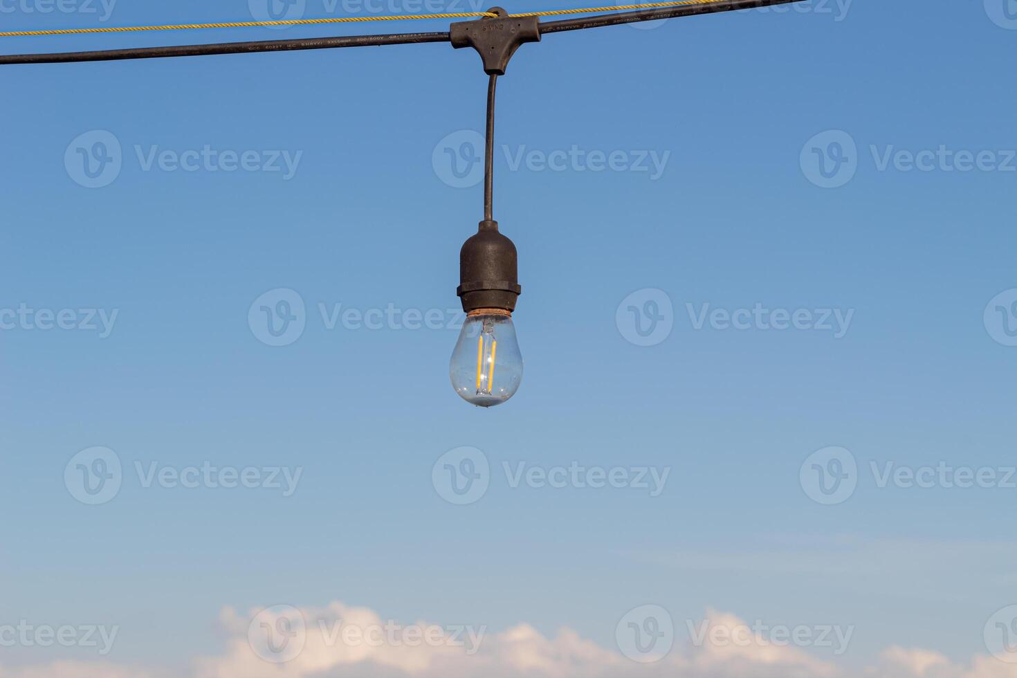 Light bulbs on a bright and slightly cloudy blue sky background photo
