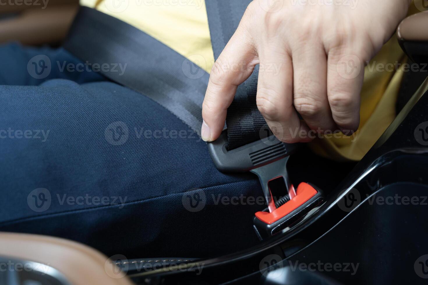 Close up of man putting on seat belt in car, midsection photo