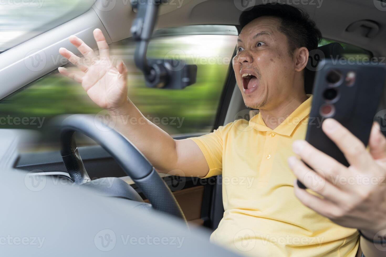 Oh my God, I am going to crash. Careless driver avoiding an accident after using phone in car checking his smartphone photo
