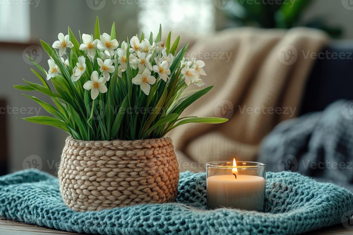 Scented candle burning next to purple flowers in a cozy living room photo