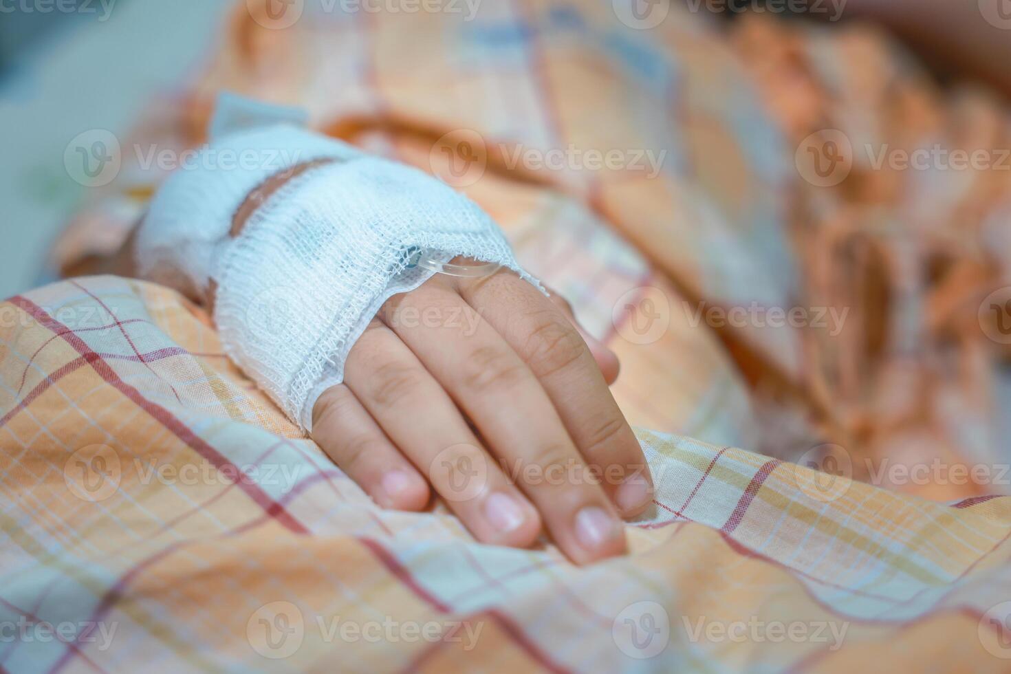 Close up child hand with tube of normal saline infusion at the hospital because it is influenza A. Hand of a patient in Hospital ward. Concept about treatment, emergency, medical, chemotherapy, sick. photo