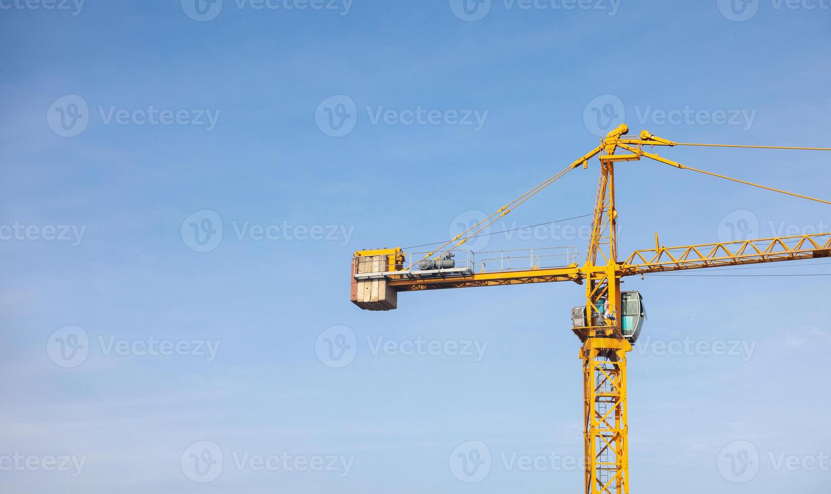 Tower cranes at construction site on sky background. Multi Storey Residential Buildings construction. Tower crane on Housing renovation. tower crane is attached to boom load secured with steel cables. photo