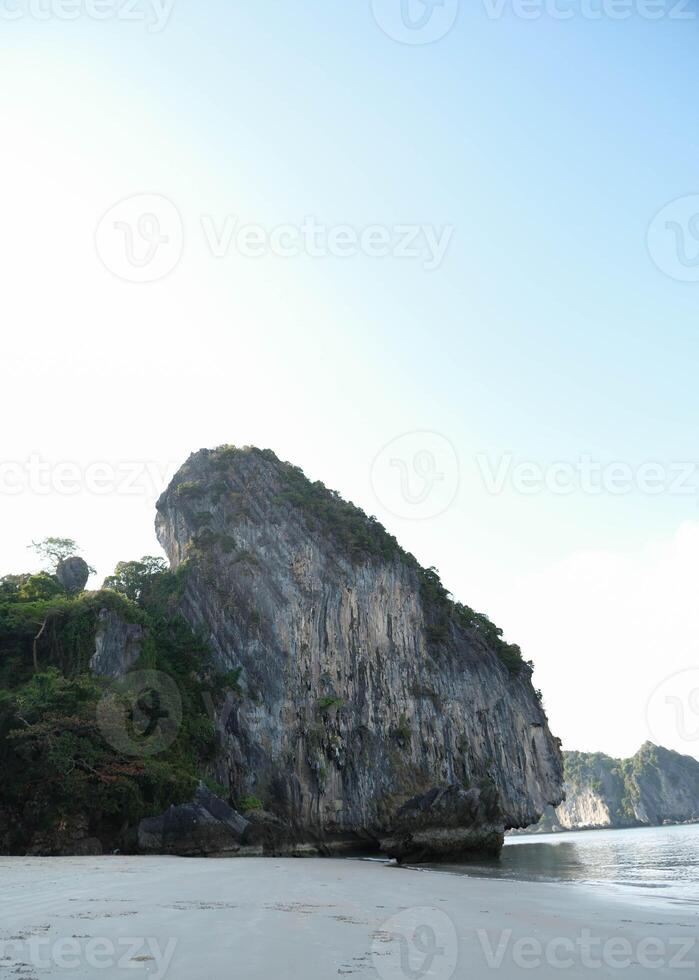 Landscape view of the rock cliff beside sandy beach at Had Yao beach, Trang province, Thailand. photo