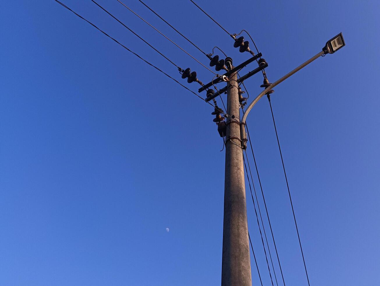 Power electric pole with line wire for residential buildings with blue sky background photo