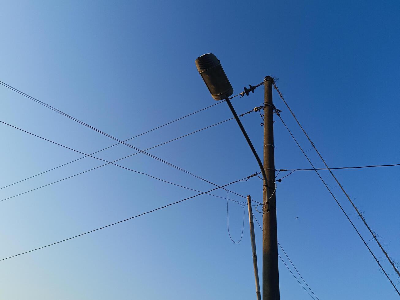 Power electric pole with line wire for residential buildings with blue sky background photo
