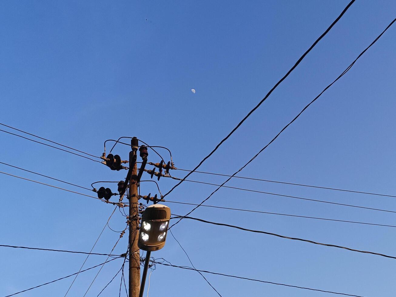 Power electric pole with line wire for residential buildings with blue sky background photo