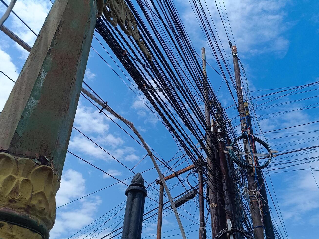 lighting lamp for street with wires running between it and blue sky background photo