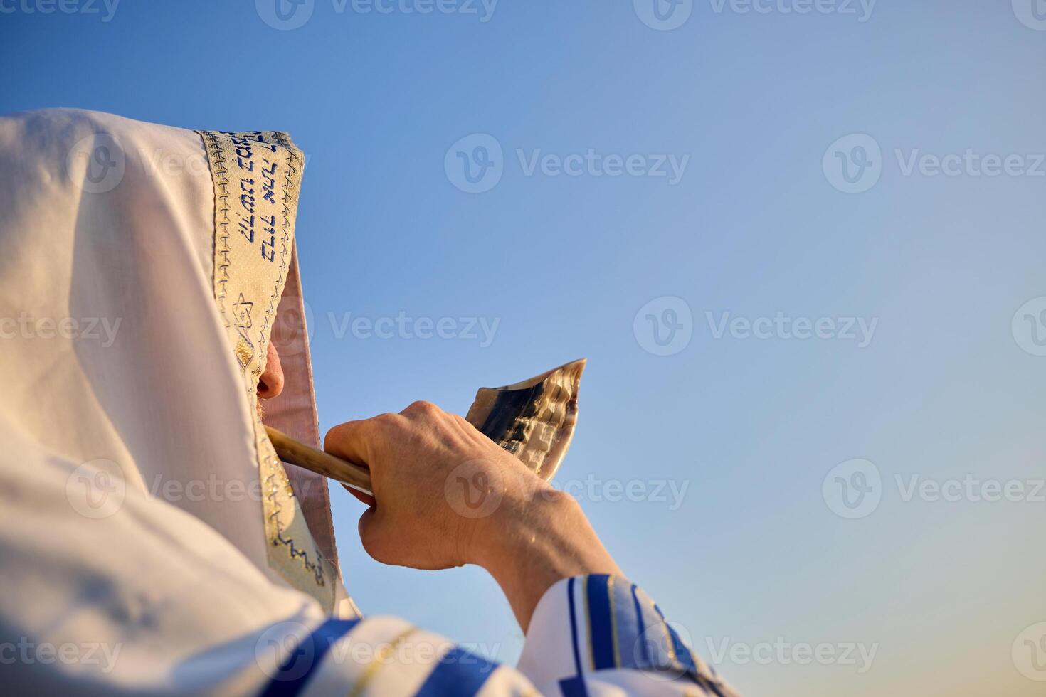 Jewish man blowing the Shofar rams horn on Rosh Hashanah and Yom Kippur day. photo