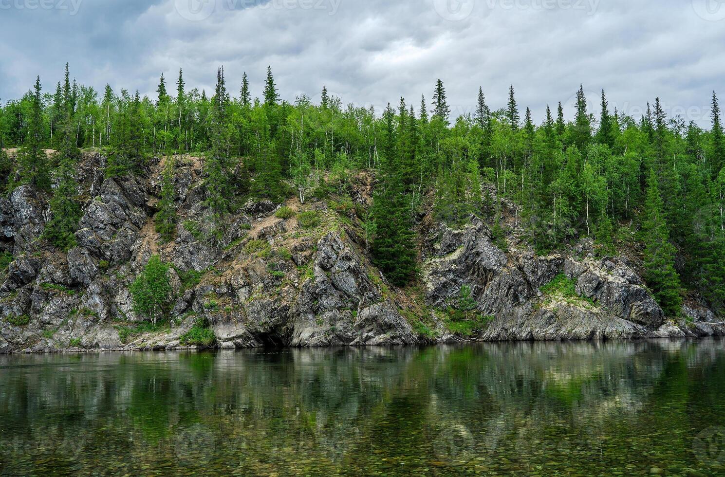 Rocks green in the reflection of the lake with a transparent bottom photo