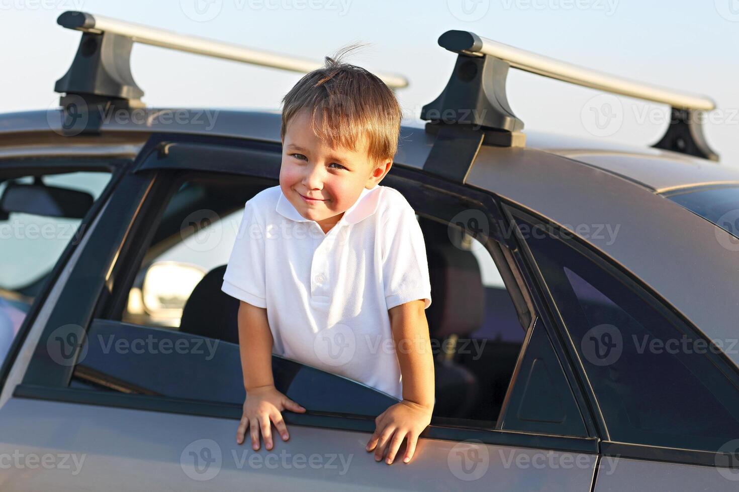 Portrait of a smiling little boy at beach in the car photo