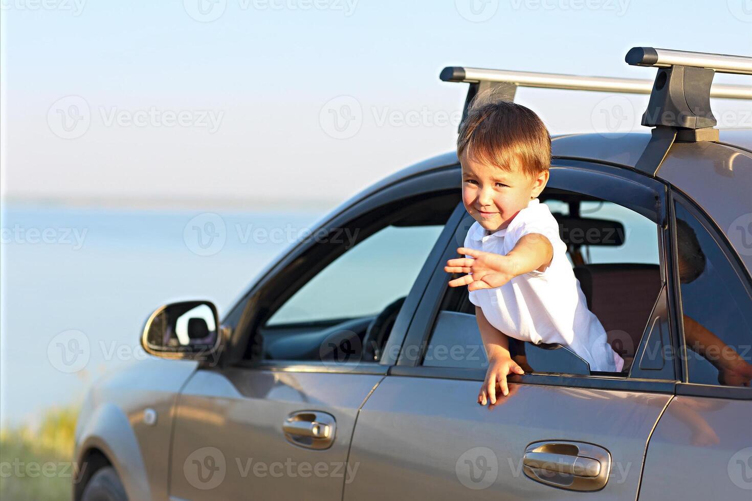 Portrait of a smiling little boy at beach in the car photo