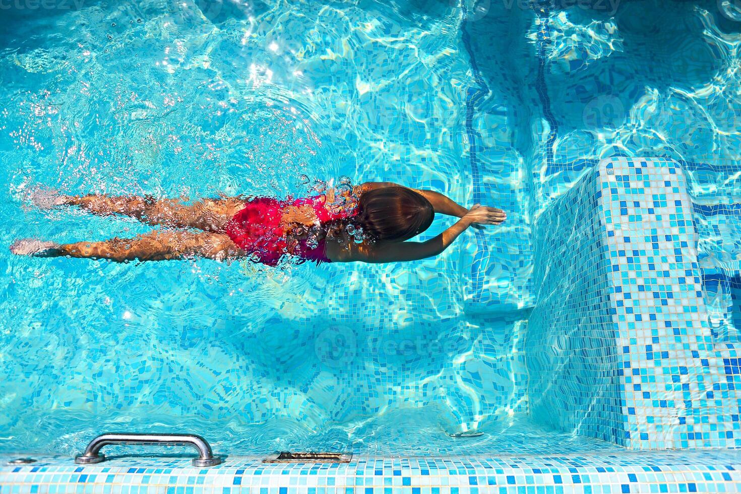 Little girl swimming in the pool photo